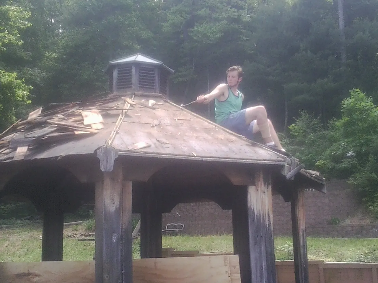 Tearing the old roof off a wooden gazebo before new shakes in Kirkwood